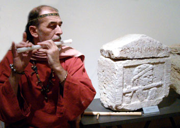 Walter Maioli tocando la flauta junto a la urna de alabastro Volumni, Perugia 2006